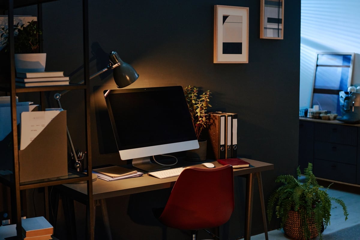 Dimly lit modern office with documents on shelves representing the structural, organized approach of content infrastructure versus ad-hoc content marketing