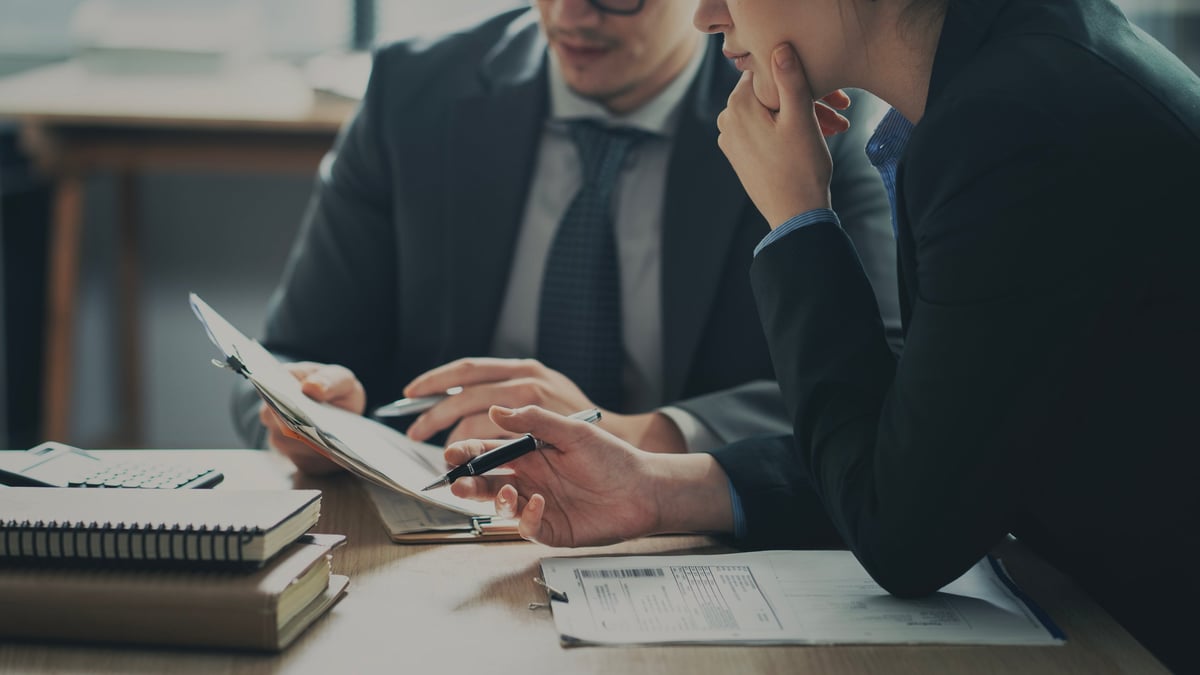 Business professionals in a meeting reviewing content on a screen representing how long-form Content360 articles support and enhance the sales conversation process